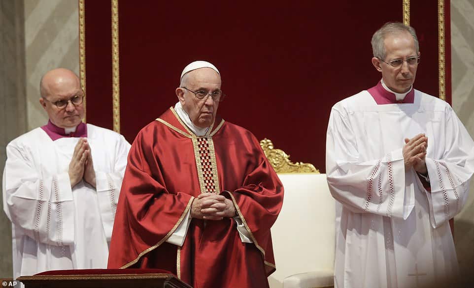 Pope Francis prostrates himself in St Peter's Basilica for Good Friday service as he rests his head on a red pillow and prays