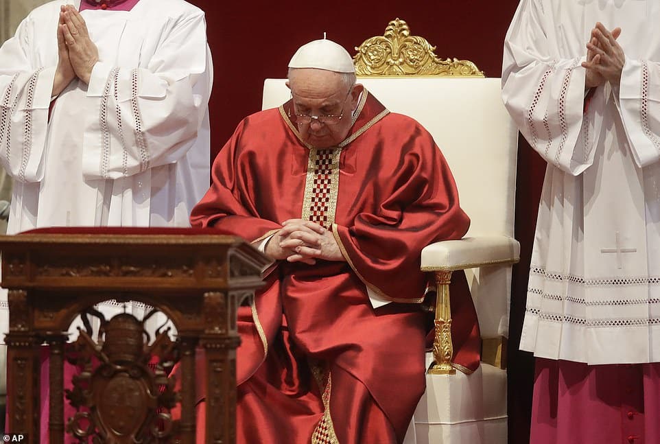 Pope Francis prostrates himself in St Peter's Basilica for Good Friday service as he rests his head on a red pillow and prays